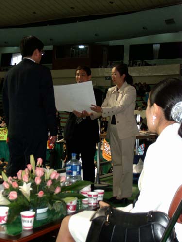 El Gran Maeestro In Sun Seo, 10º dan de Hapkido y presidente de la World Kido Federation lee el diploma que entregará al maestro Doo Hyung Cho, presidente de la asociación Kido España de Hapkido
